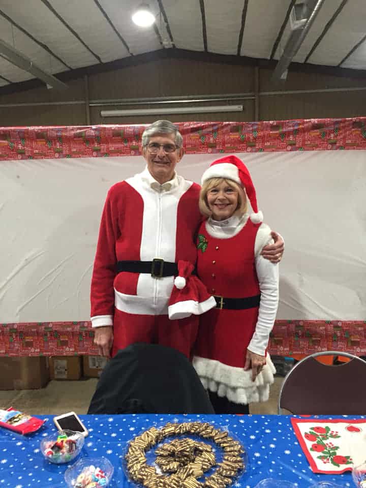 Two people dressed as Santa and Mrs. Claus